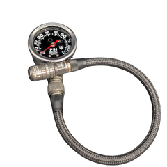 A PSI gauge with a round black face, silver metal casing, and a coiled gray braided hose, isolated on a white background.